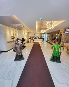 two statues of people on a red carpet in a lobby at Hotel Gongjicheon in Chuncheon