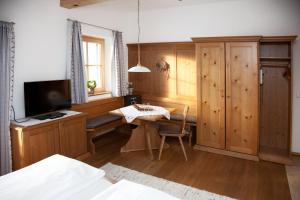 um quarto com uma secretária, uma televisão e uma mesa em Filzenhof em Kitzbühel