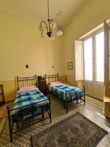 a bedroom with two beds and a chandelier at Residenza Maria Letizia in Milo