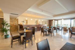 un restaurant avec des tables et des chaises ainsi qu'un bar dans l'établissement Porto Plaza Hotel, à Agios Ioannis Kaspaka