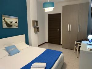 Schlafzimmer mit einem Bett mit blauer Wand in der Unterkunft URBANFLAT SALENTO in Lecce
