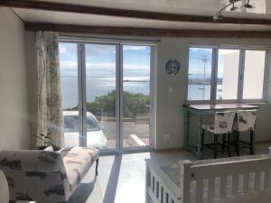 a living room with a couch and a view of the ocean at Blue Bay Studio Bayview in Cape Town