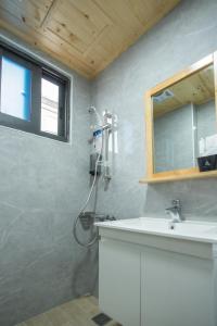 een badkamer met een douche en een wastafel bij Shan Shui Hostel in Hualien