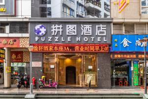 un edificio con escritura asiática en la parte delantera en Puzzle Hotel - Zhongshan 8th Road Chenjiaci Subway Station Branch en Cantón