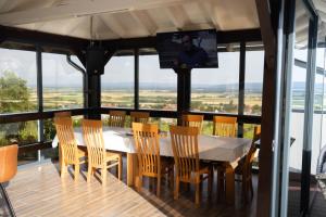 uma sala de jantar com uma mesa e cadeiras e uma televisão em King's Hill kuća za odmor em Velika