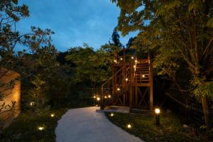 a path leading to a tree house at night at SEN RETREAT CHIKATSUYU - Kumano Kodo Gateway in Tanabe
