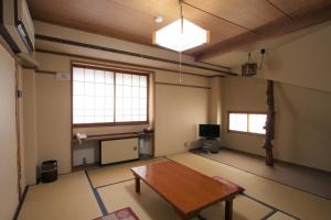 an empty room with a table in the middle at Kawahiro in Nozawa Onsen