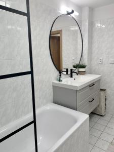 a bathroom with a tub and a sink and a mirror at Family Ski apartment in Špindlerův Mlýn