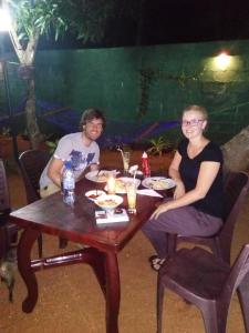 two women sitting at a wooden table with food at Hotel MOONSTONE in Anuradhapura