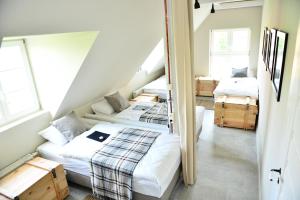 una camera con tre letti e due finestre di Five Point Hostel & Apartments a Danzica