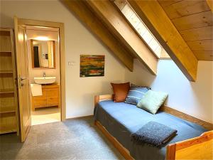 a bedroom with a bed and a sink in a room at apartmány V Lese in Bedřichov