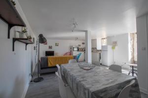 salon ze stołem i krzesłami oraz kuchnię w obiekcie Duplex 4/5 personnes sur cour w mieście Plouër-sur-Rance