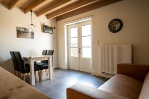 un soggiorno con tavolo, sedie e finestra di Bed and Breakfast Paellepelhoeve a Ninove