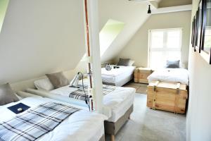 una stanza con tre letti e un divano di Five Point Hostel & Apartments a Danzica
