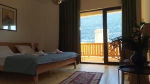 a bedroom with a bed and a view of a balcony at Hotel Lamish in Mestia
