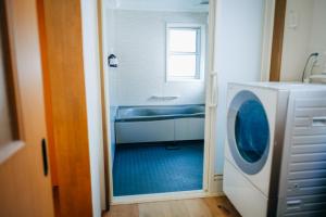 a bathroom with a washing machine and a sink at 石打丸山スキー場徒歩30秒一棟まるまる貸切フルリノベーションのお宿 in Seki