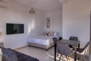 una camera con letto, tavolo e divano di Phaedrus Living: City Flat Palas 101 a Paphos