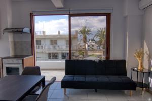 un soggiorno con divano e una grande finestra di Phaedrus Living: City Flat Palas 101 a Paphos
