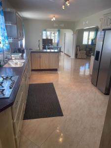 a kitchen with a large kitchen with a refrigerator at ‘MAYARO’ Private Room with Ocean View in Saint Philip