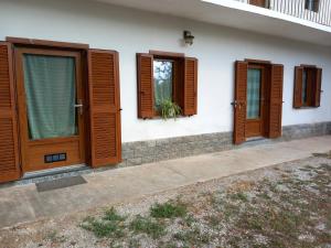 een huis met houten deuren en ramen erop bij Ca' di Burghi 2 in Busca