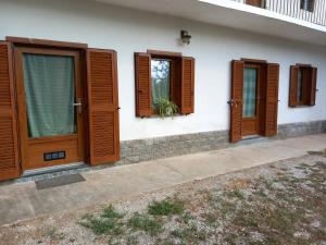 a house with wooden doors and windows on it at Ca' di Burghi 2 in Busca