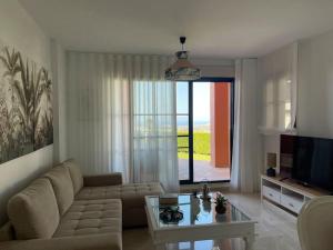 a living room with a couch and a glass table at Bonito apartamento con jardín privado in Finestrat