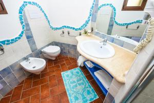 a bathroom with two sinks and a toilet at Faunele in Orosei