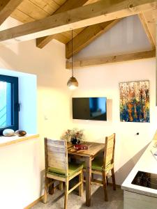 a dining room with a wooden table and chairs at apartmány V Lese in Bedřichov