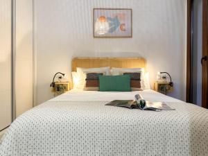 a bedroom with a bed with a book on it at Casa Vega. Coqueto apartamento en Casco Antiguo. in Alicante