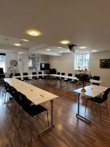 ein großes Zimmer mit Tischen und Stühlen in der Unterkunft Hotell Dannegården in Trelleborg