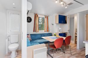 a small kitchen with a blue couch and a table and chairs at First Camp Oknö-Mönsterås in Mönsterås