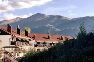 ein großes Gebäude mit Bergen im Hintergrund in der Unterkunft Chalet Elegante - Campo Felice e Piste da scii in Spogna