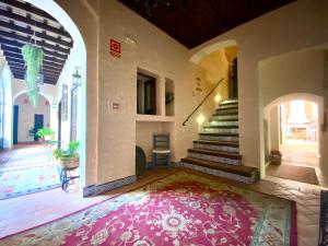 um corredor com um tapete rosa no chão e escadas em El Rincón de las Descalzas em Carmona