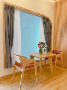 a dining room table and chairs with a window at Sea House Hotels and Apartments in Vung Tau