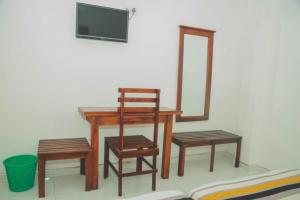 a wooden table and two chairs and a mirror at Hotel MOONSTONE in Anuradhapura