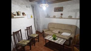 sala de estar con sofá, sillas y mesa en Mirador del Castillo Rural House, en Castillo
