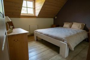 ein Schlafzimmer mit einem großen Bett im Dachgeschoss in der Unterkunft Bed and Breakfast Paellepelhoeve in Ninove