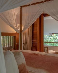 a bedroom with a bed and a large window at Bisma Eight Villas in Ubud