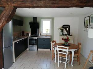 eine Küche mit einem Tisch und Stühlen in der Unterkunft Le gîte d'Eva in Honfleur