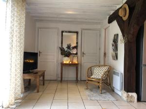 un salon avec une chaise et un miroir dans l'établissement Le gîte d'Eva, à Honfleur