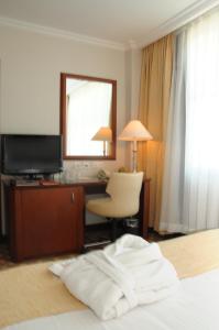 a hotel room with a desk and a mirror at Hotel Midi in Ankara