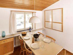 eine Küche mit einem Tisch mit Stühlen und einem Fenster in der Unterkunft Adele (704 De) in Lenzerheide