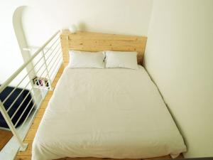 - un lit avec des draps et des oreillers blancs dans l'établissement Il loft sotto la Mole, à Turin