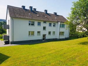 duży biały dom z trawnikiem w obiekcie Wohnung in Herscheid w mieście Herscheid