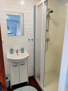 a white bathroom with a sink and a shower at Maringotka Nebeská in Chýnov +19 photos