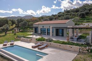 een villa met een zwembad en een huis bij Ktima Agrapidos - Grandpa Villa in Póros