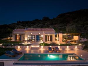 una casa con piscina por la noche en Ktima Agrapidos - Grandpa Villa, en Póros