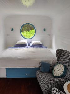 a bedroom with a bed and a window and a clock at Maringotka Nebeská in Chýnov