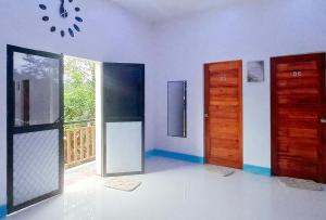 RedDoorz @ SCJS INN Buug Sibugay في Buug: غرفة فارغة فيها بابين ونافذة