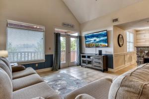a living room with two couches and a flat screen tv at Owl See You 3205 - Close to Dollywood and Overlooking Gatlinburg Golf Course condo in Pigeon Forge